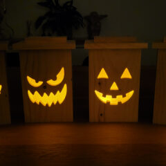 DIY wooden jack-o’-lantern lantern made from cedar fence board with carved Halloween pumpkin face.