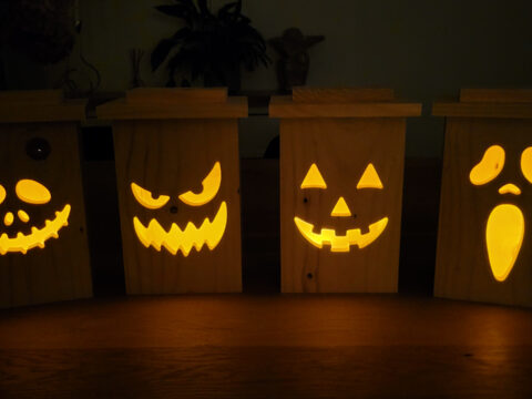 DIY wooden jack-o’-lantern lantern made from cedar fence board with carved Halloween pumpkin face.